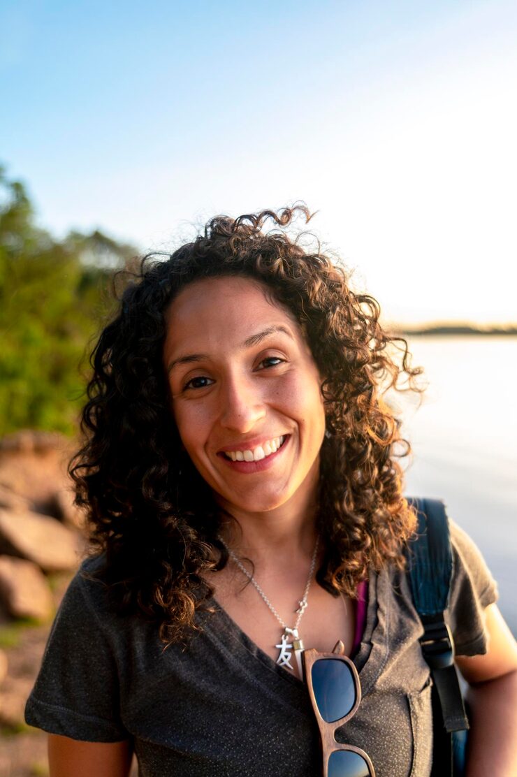 mixed race woman looking camera smiling while enjoying outdoors sunset 1048944 6077119